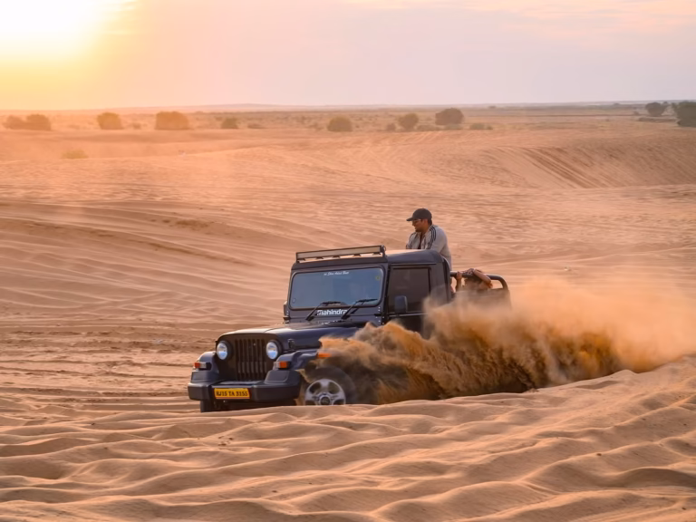 4x4 jeep driving across desert dunes in Jaisalmer