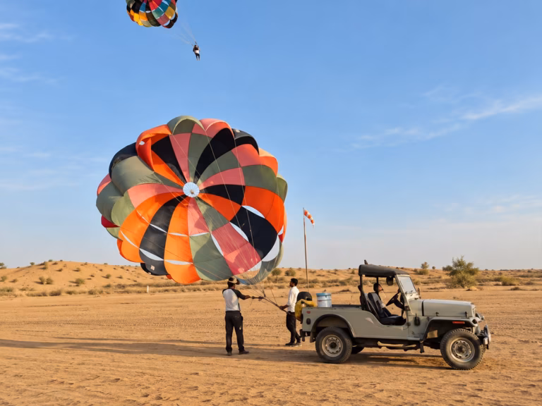 Jeep pulling a parasailing rider across the desert in Jaisalmer