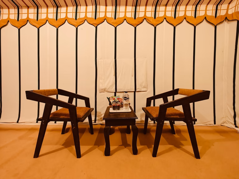 Indoor seating area with wooden chairs inside the Super Deluxe Swiss Tent