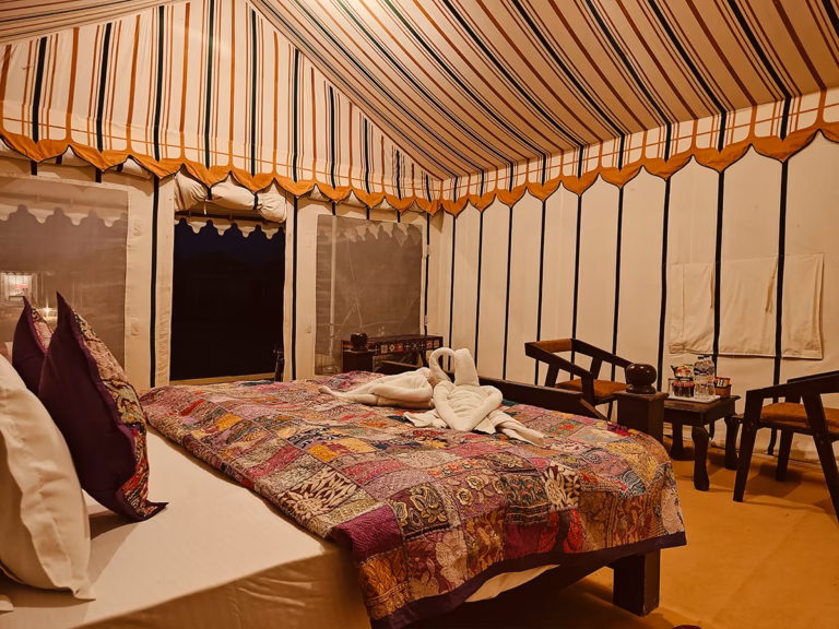 King bed with colourful linen inside the Super Deluxe Swiss Tent